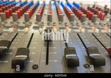 A close up of a sound mixing desk with dials, levels, levels and buttons. Stock Photo