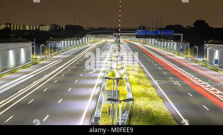 Motorway with tunnel at night with blurred car lights by long exposure Stock Photo