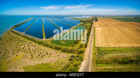 Aerial panoramic view of waste water treatment plant pools and plowed fields
