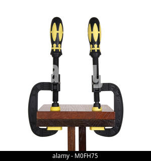 clamps of yellow color hold two wooden bars on a white background. Use F-clamp to holding or catch wood in woodworking. Stock Photo