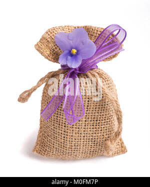 jute sack with ribbon and african violet flower isolated Stock Photo