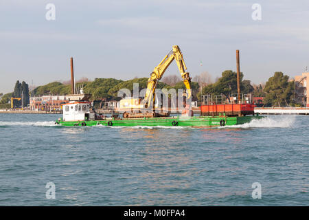 Large heavy duty  industrial crane with hydraulic hoist being transported on a barge in the Venetian lagoon,  Basino San Marco, Venice, Italy Stock Photo