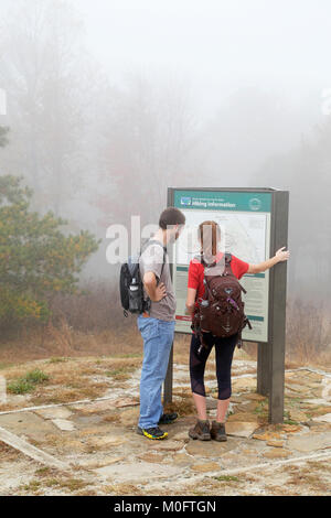 Hikers looking at trail map, Pilot Mountain, North Carolina. Stock Photo