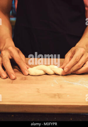 man kneading raw donut dough Stock Photo