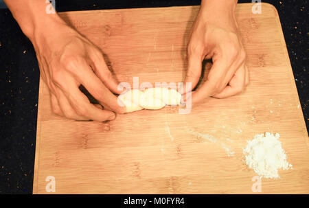 man kneading raw donut dough Stock Photo