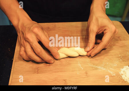 man kneading raw donut dough Stock Photo