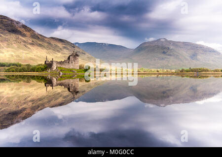 The ruins of Kilchurn Castle, home of the Clan Campbells of Glenorchy, and the mountains of Argyll are reflected in the calm waters of Loch Awe in the Stock Photo