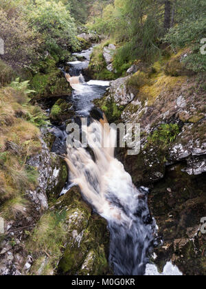 A mountain stream, Allt Clais nam Foid, tumbles through woodland in Strath Kyle in the northern Highlands of Scotland. Stock Photo