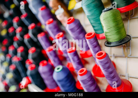 Colorful threads on spools closeup, sewing material, yarn on bobbins macro view Stock Photo
