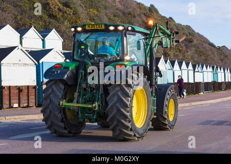 Tractor going along promenade at Middle Chine ready to move and level the sand on the beach at Bournemouth, Dorset UK in January Stock Photo