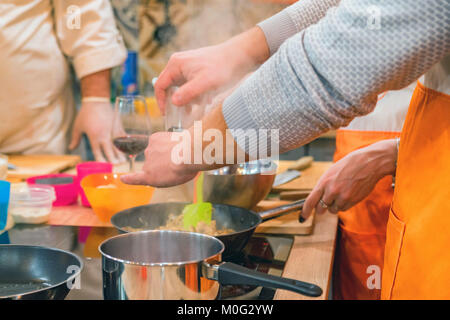 Close up male hands adding pepper to meat in frying pan at culinary workshop Stock Photo