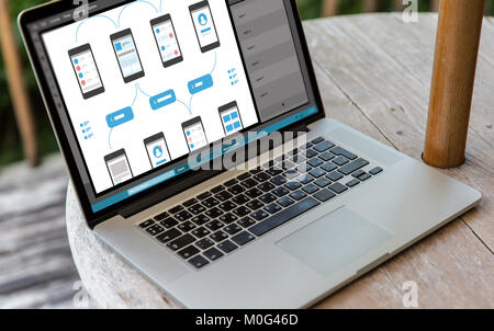 laptop with smartphone interface design on screen Stock Photo