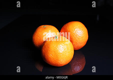 Mandarins. Mandarin citrus orange fruit mandarins on black reflective studio background. Isolated black shiny mirror mirrored background for every con Stock Photo