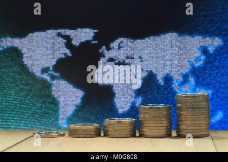 World of idea. Coin pile stacked in increasing chart shape on wood board with White dots grid pattern world map on digital blue and green color dot. Stock Photo