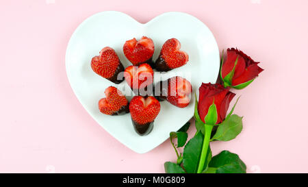Happy Valentine's Day overhead flat lay with heart shaped strawberries dipped in chocolate. Stock Photo