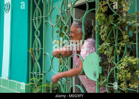 Women passing time behind home security bars, Havana, Cuba Stock Photo