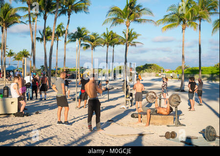 MIAMI - DECEMBER 27, 2017: Muscular young men attract onlookers working out at the outdoor workout station in Lummus Park known as Muscle Beach. Stock Photo