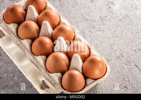Farm raw fresh egg in pack on gray table scrambled eggs omelet fried egg Stock Photo