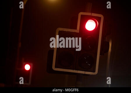 red stop light traffic lights on a foggy evening at night in the uk Stock Photo