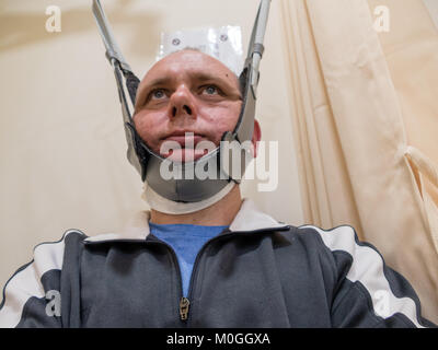 Man in neck traction machine for physiotherapy Stock Photo