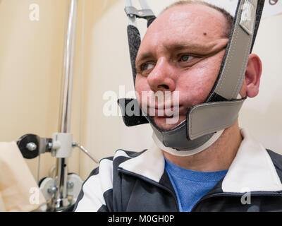 Man in neck traction machine for physiotherapy Stock Photo