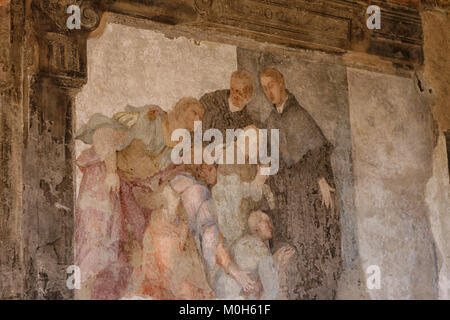 Beautiful medieval fresco inside a monastery of two priests/monks with village people praying at their feet Stock Photo