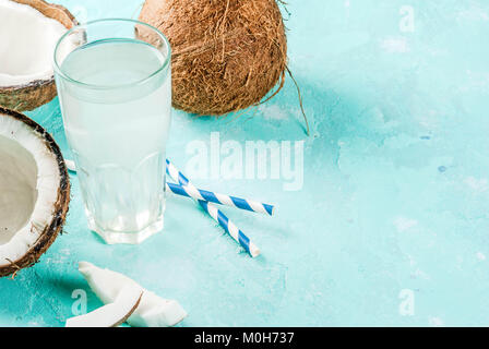 Healthy food concept.  Fresh Organic Coconut Water with coconuts, ice cubes and mint, on light blue background, copy space Stock Photo