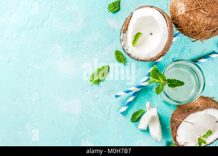 Healthy food concept.  Fresh Organic Coconut Water with coconuts, ice cubes and mint, on light blue background, copy space top view Stock Photo