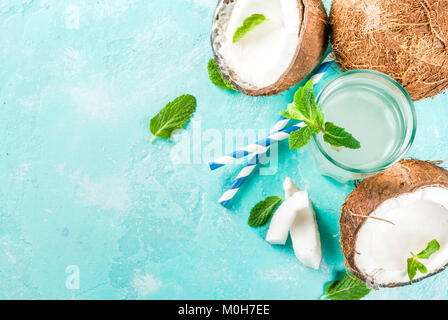 Healthy food concept.  Fresh Organic Coconut Water with coconuts, ice cubes and mint, on light blue background, copy space top view Stock Photo
