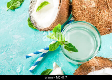 Healthy food concept.  Fresh Organic Coconut Water with coconuts, ice cubes and mint, on light blue background, copy space top view Stock Photo