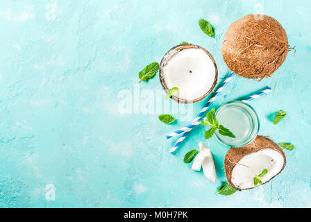Healthy food concept.  Fresh Organic Coconut Water with coconuts, ice cubes and mint, on light blue background, copy space top view Stock Photo