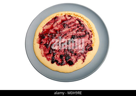 Pancake on blue plate with red fruits jam isolated on white. Clipping path Stock Photo