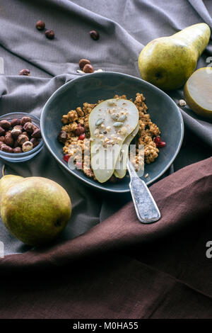 overhead view of bowl with granola and pear on table Stock Photo
