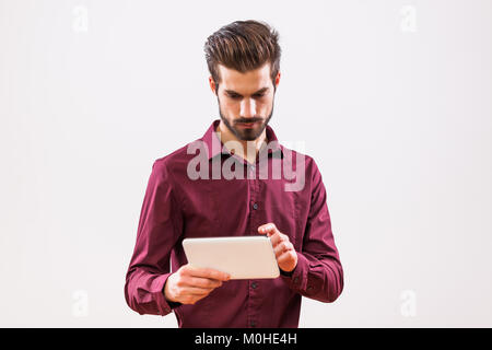 Studio shot portrait of young businessman who is using tablet. Stock Photo