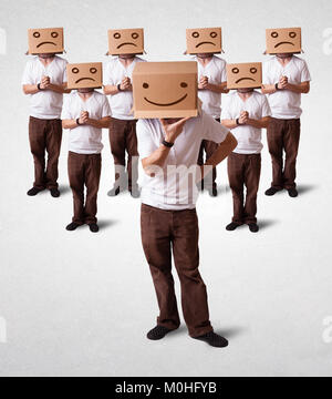 Group of handsome people gesturing with sketched smiley faces on box Stock Photo