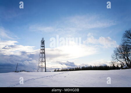 Snowy winter country with transmitters and aerials on telecommunication tower Stock Photo