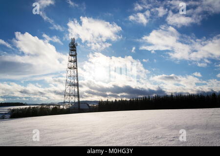 Snowy winter country with transmitters and aerials on telecommunication tower Stock Photo