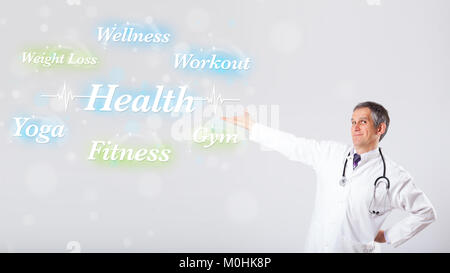 Elderly clinical doctor pointing to health and fitness collection of words Stock Photo