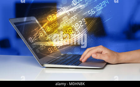 Man typing on modern notebook with future number technology data coming out Stock Photo