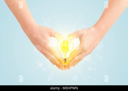 Hands creating a form with yellow light bulb in the center Stock Photo