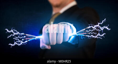 Business person holding electrical powered wires concept on background Stock Photo