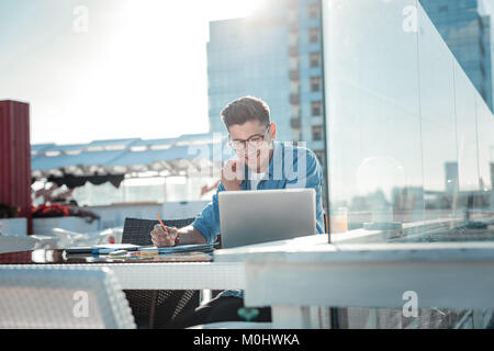 Smiling guy preparing for exams outdoors Stock Photo