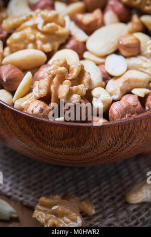 Mixed nuts including hazelnuts, walnuts, blanched almonds and cashews in wooden bowl Stock Photo
