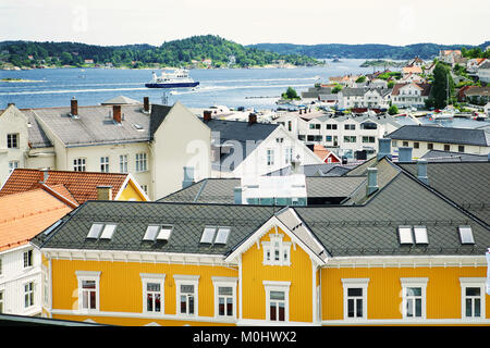 A panoramic view with house rooftops and ship in distance at town of Kragero in Norway. Stock Photo