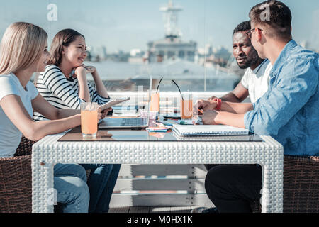 Group of young freelancers meeting in cafe for lunch Stock Photo