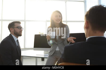 colleagues chatting while enjoying coffee break in the office Stock Photo