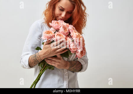 the girl is holding a bouquet of pink roses Stock Photo