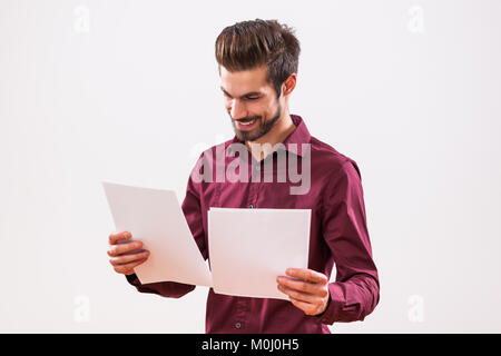 Portrait of young businessman who is looking at documents. Stock Photo