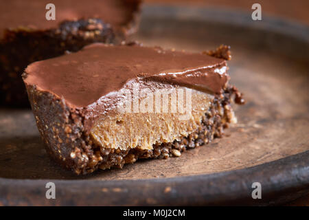 Vegan mini cakes made with walnuts, dates, caramel creme and covered with chocolate Stock Photo
