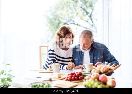 Senior couple eating breakfast at home. Stock Photo